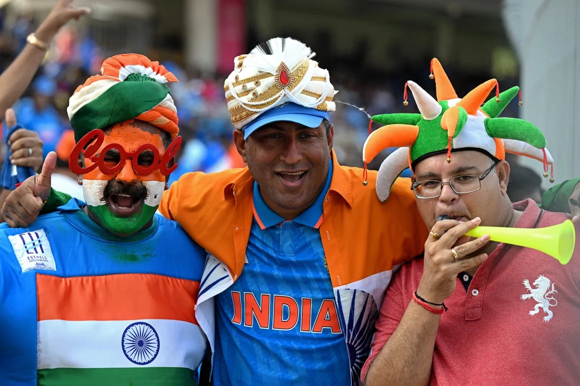 Fans from India and Pakistan smiling together outside a stadium.