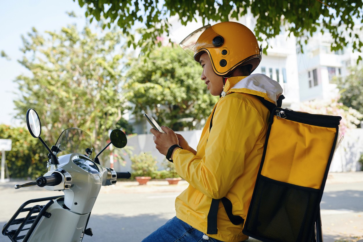 A delivery courier checking an app on their phone.