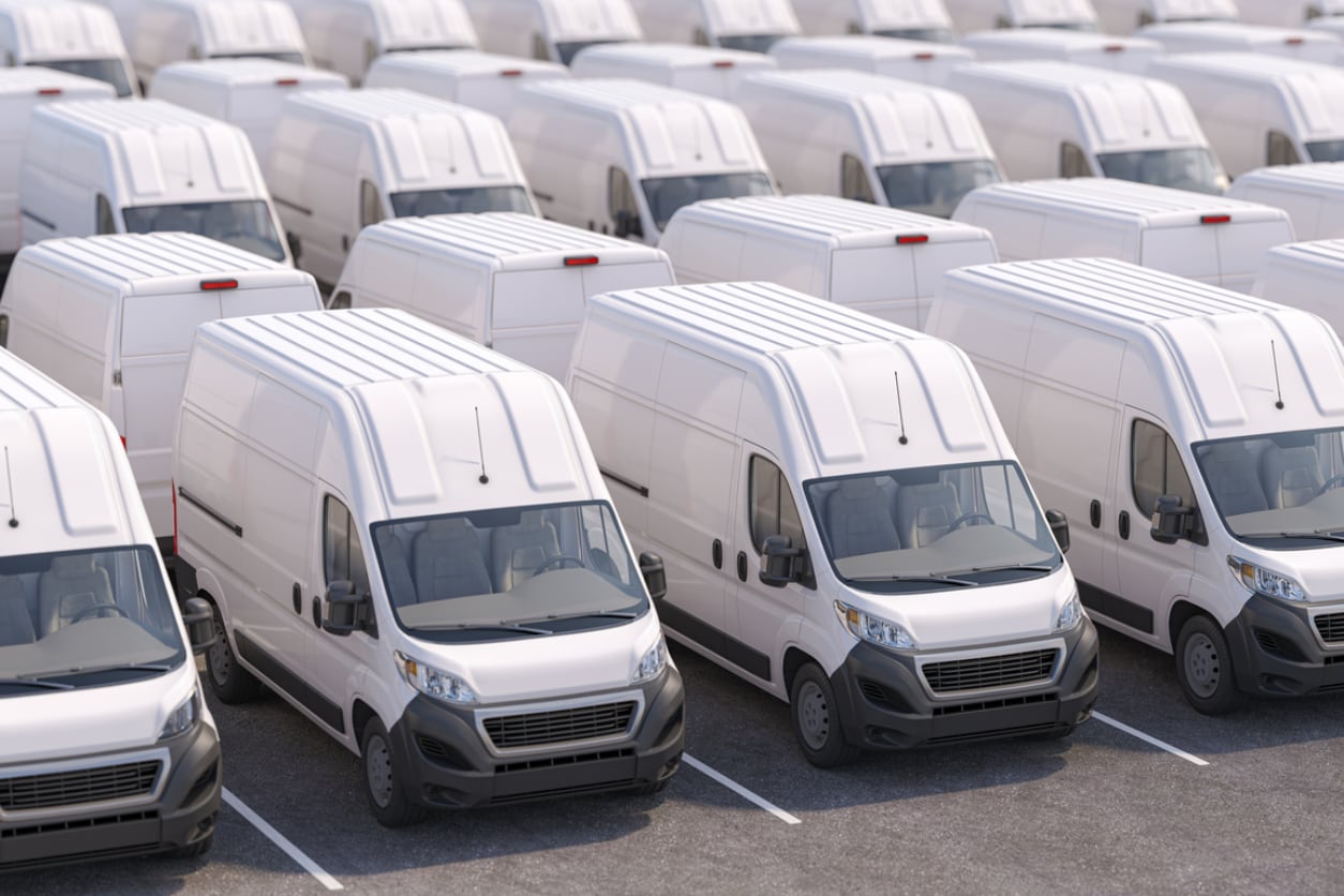 An electric delivery van plugged into a charger.