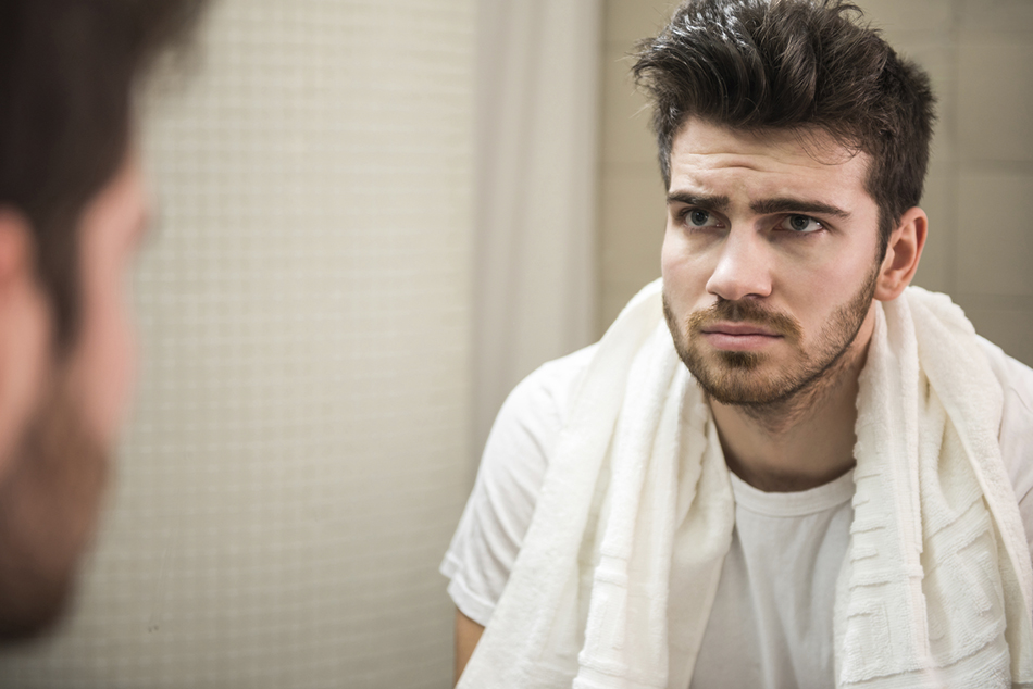 Guy looking at himself in the mirror